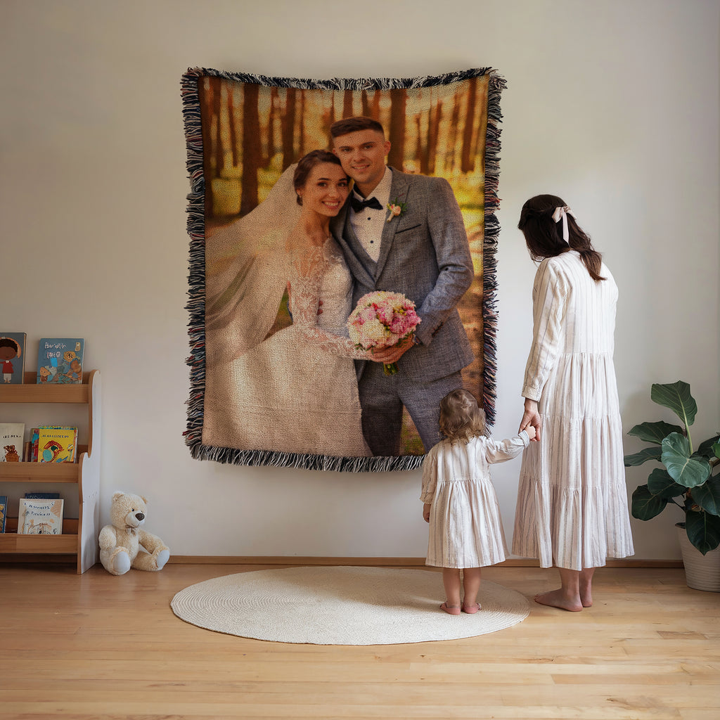 Custom woven photo blanket of a wedding portrait hung on a living room wall while a mother and daughter look up at it